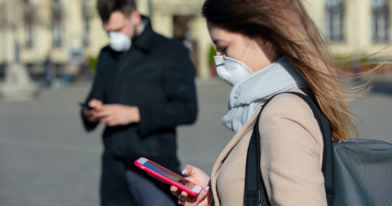 people in masks looking at phones
